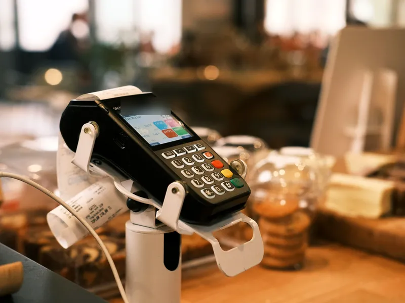 A close-up of a card machine on a café counter