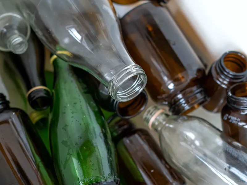 Used glass bottles in green, brown and clear sorted for recycling