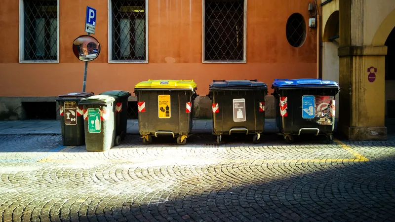 Commercial recycling bins lined up outside a building