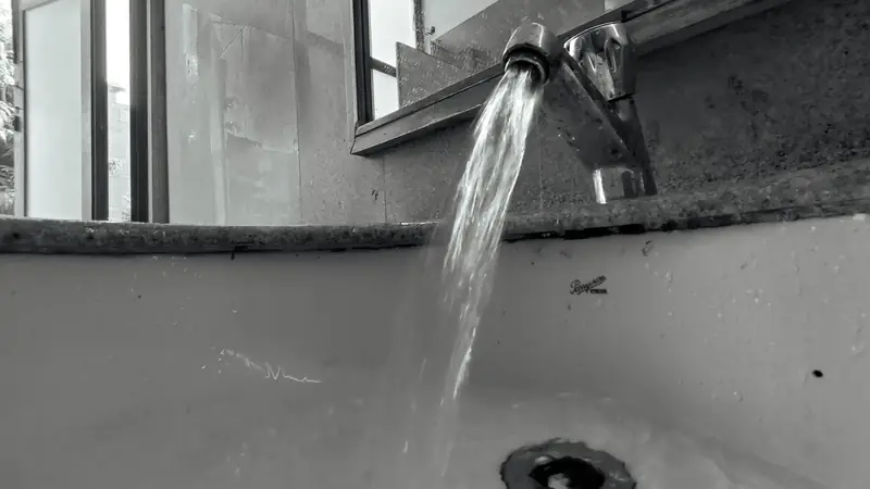 Water running from a tap into a sink